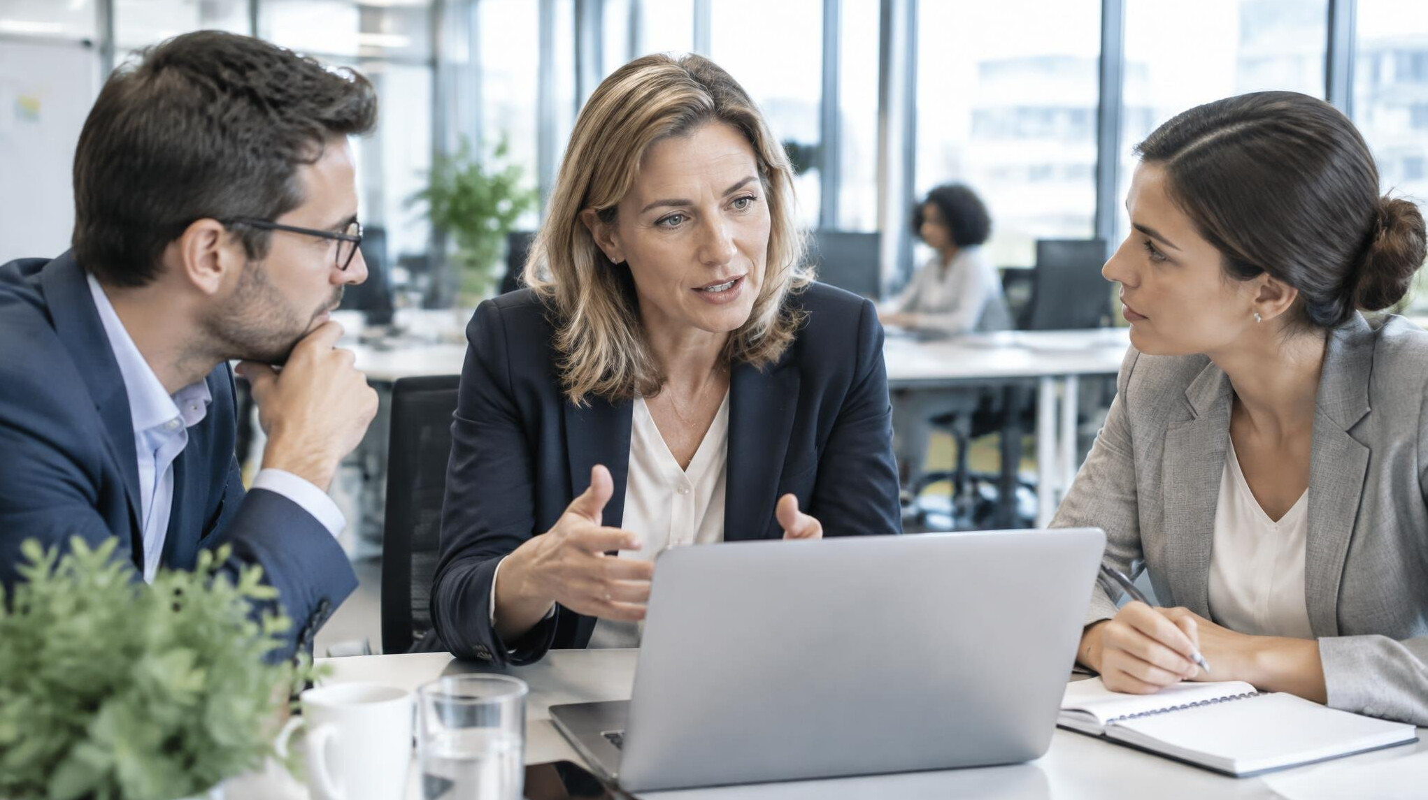 Manager guiding a discussion with colleagues in an office